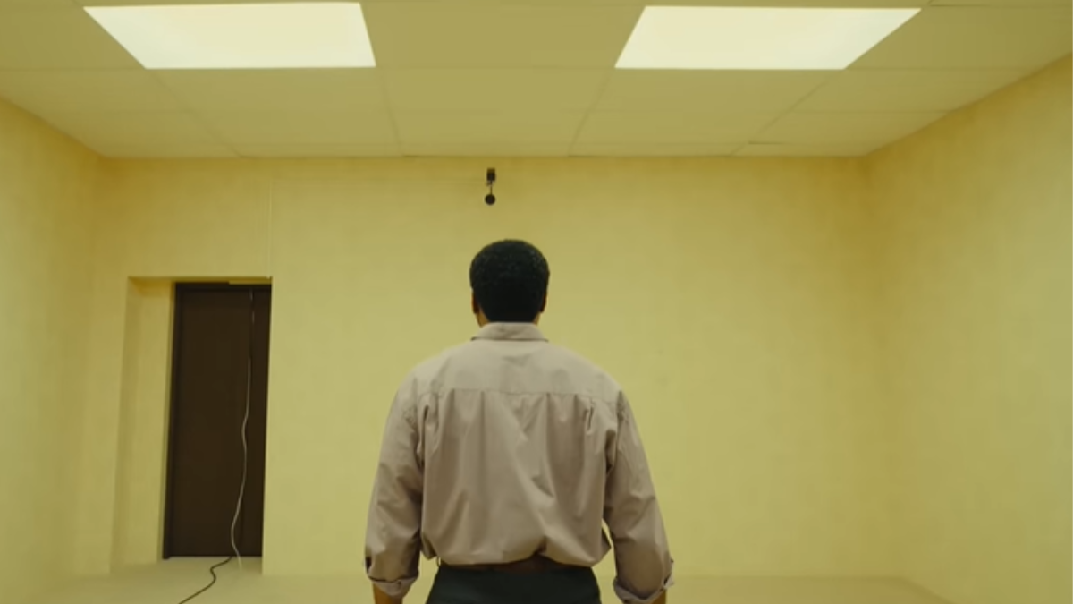 Homem de costas em uma sala amarela. A cena foi retirada do trailer do filme Backrooms da A24