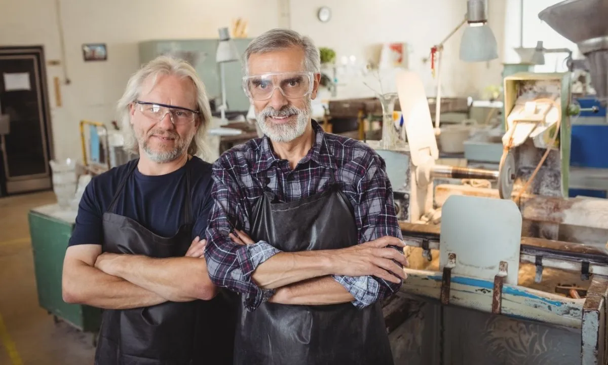 dois idosos de braços cruzados no trabalho simbolizando a economia prateada no Brasil