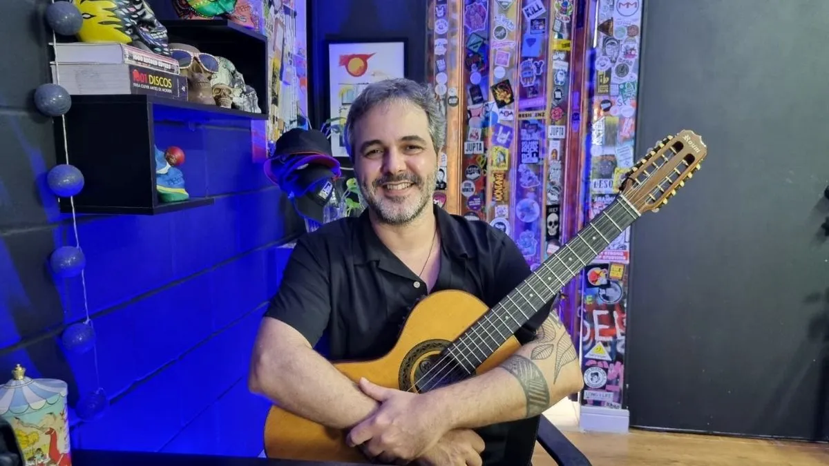 Foto de Lula Fidalgo abraçando o violão