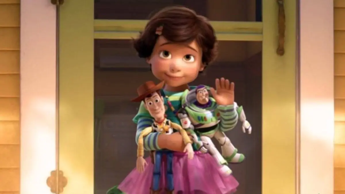 Bonnie com Buzz e Woody na mão e os brinquedos no chão