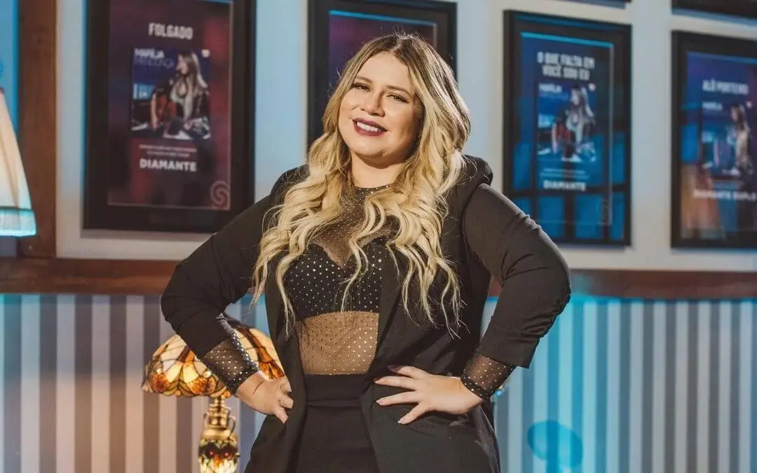 Foto de Marilia Mendonça de roupa preta com as mãos na cintura